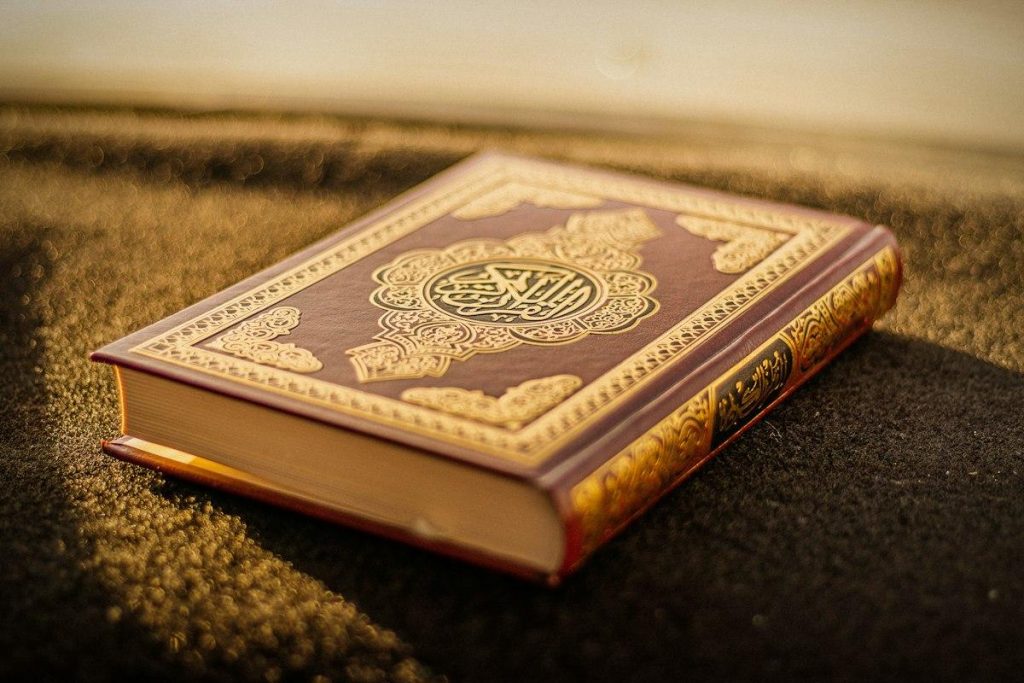 A Quran with an ornate cover in warm evening light